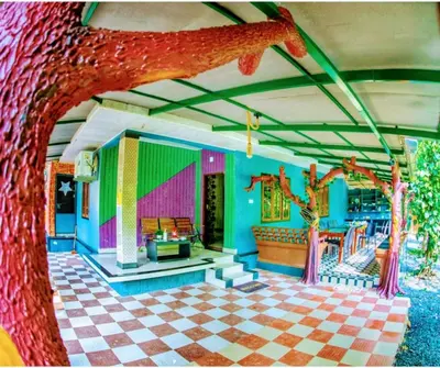 a living room with a couch and a tree at Holy Village Homestay in Neriyamangalam