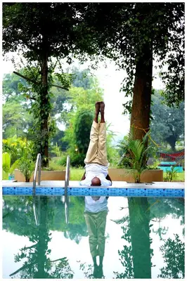 a person sitting on the edge of a swimming pool at Vajra Periyar Heritage in Alwaye