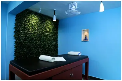 a green wall in a bathroom with a table with towels at Vajra Periyar Heritage in Alwaye