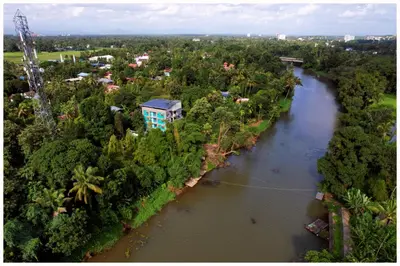 an aerial view of a river with trees and buildings at Vajra Periyar Heritage in Alwaye