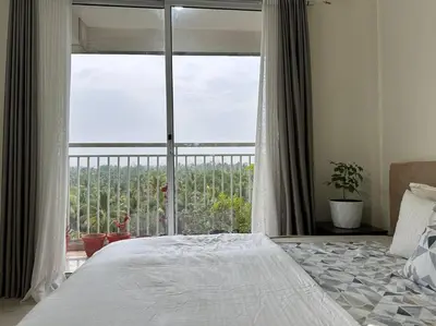 a bedroom with a bed and a large window at Memmsta Blooming Bird Guruvayur in Guruvāyūr