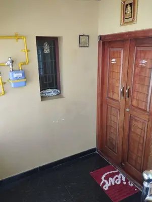a room with a wooden door and a red rug at NJM Villa in Coimbatore