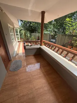 a balcony with a bench and some plants at Nature's View Service Villa in Vythiri