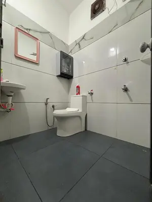 a bathroom with a toilet and a sink at Nature's View Service Villa in Vythiri