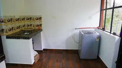a bathroom with a sink and a small refrigerator at Prakruthi Home stay in Kanjikode