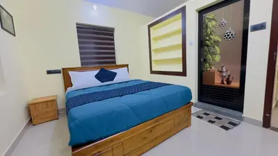 a bedroom with a bed with a blue comforter at Golden pearl private villa with pool in Vythiri