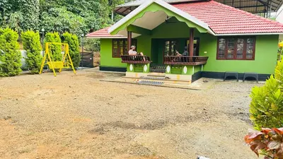a small green house with a playground in the yard at Golden pearl private villa with pool in Vythiri