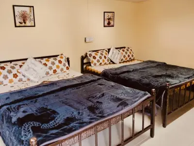 two beds sitting in a room with at HRS Budget Rooms in Ooty