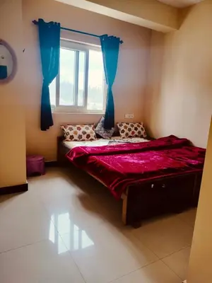 a bedroom with a large bed with a window at HRS Budget Rooms in Ooty