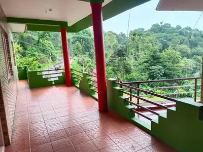 a balcony with a view of the forest at Abiraksha Stay Coorg in Madikeri