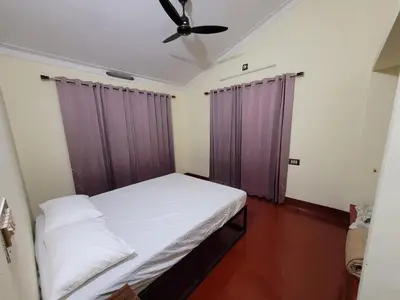 a bedroom with a bed and a ceiling fan at The Forest Temple in Kaniyāmbetta