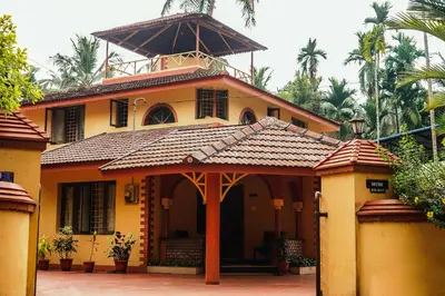 a yellow house with a tower on top of it at Boughn Villa in Kozhikode