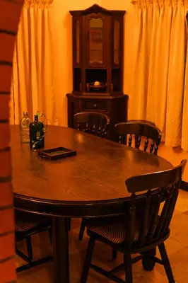 a dining room table with chairs and a cabinet at Boughn Villa in Kozhikode