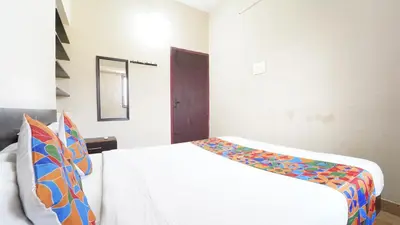 a bedroom with a white bed with a colorful blanket at Hotel Varun 1 bhk in Coimbatore