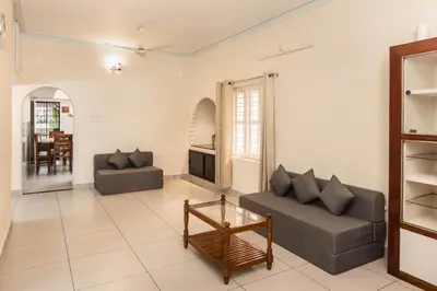 a living room with two couches and a table at Chitralayam Home stay in Guruvāyūr