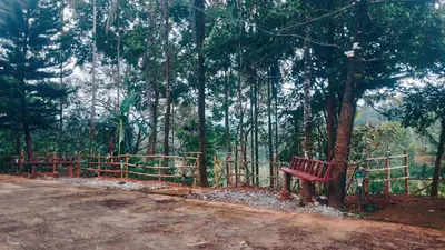 a red bench sitting next to a fence in a forest at JoeAnn Villa in Kalpetta