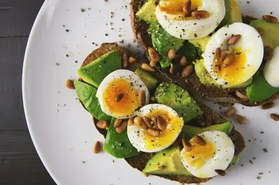 a plate of food with eggs and avocado and nuts at JoeAnn Villa in Kalpetta