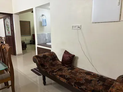 a couch sitting in a living room next to a wall at Moms Villa in Nedumbassery