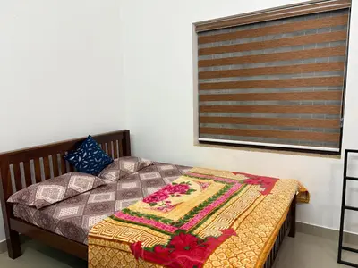 a bedroom with a bed with a blanket on it at Moms Villa in Nedumbassery