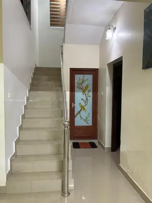 a stairway with a wooden door and a staircase with a stair railing at Moms Villa in Nedumbassery