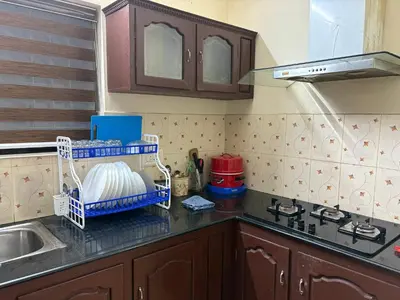 a kitchen with a sink and a counter top at Moms Villa in Nedumbassery