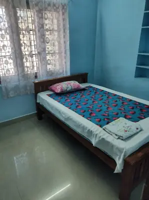 a bed sitting in a room with a window at Beautiful and Peaceful house in Kanjikode