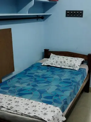 a bed in a room with a blue wall at Beautiful and Peaceful house in Kanjikode