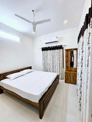 a bedroom with a bed and a ceiling fan at Mariya Home Stay in Kanjikode