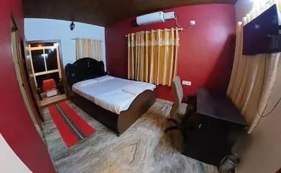 a bedroom with a bed and a desk and a chair at Homestay Rooms Muzhakkunnu Near Kannur International Airport in Iritti