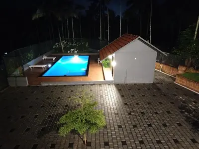 a dog house and a swimming pool at night at Wild Wind Resort in Batheri