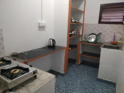 a small kitchen with a stove and a sink at Mithu's Nest-Ur Holiday Abode in Coimbatore
