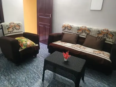 a living room with two couches and a table at Mithu's Nest-Ur Holiday Abode in Coimbatore