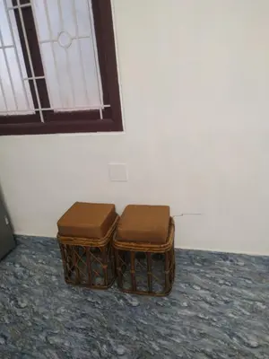 two brown stools sitting next to a wall at Mithu's Nest-Ur Holiday Abode in Coimbatore