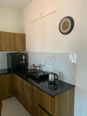 a kitchen with a stove and a clock on the wall at Gaya beach hacienda in Irimbranallūr
