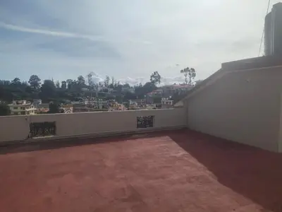 an empty balcony with a view of a city at Ooty mountain cottage in Ooty
