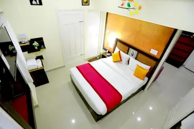 a bedroom with a large bed with a wooden headboard at Base9 Family Lounge -Cochin Airport in Nedumbassery
