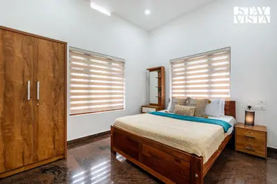 a bedroom with a bed and a large window at Stayvista at Whitewood Serene 5BHK Homestay - Wayanad in Wayanad