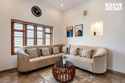 a living room with a couch and a table at Stayvista at Whitewood Serene 5BHK Homestay - Wayanad in Wayanad