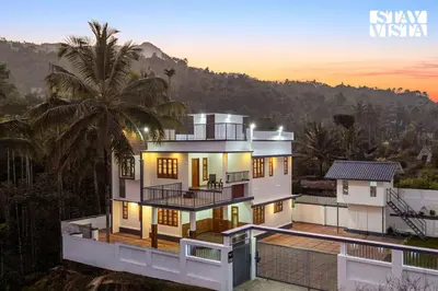 a view of a house with a palm tree at Stayvista at Whitewood Serene 5BHK Homestay - Wayanad in Wayanad