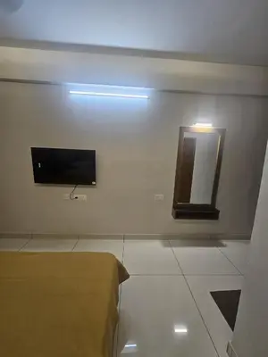 a room with a tv and a mirror on the wall at Regent Tourist Home in Palakkad