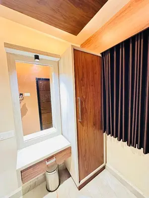 a bathroom with a mirror and a wooden door at City Palace Hotel in Ooty