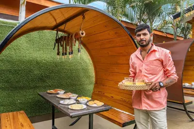 a man standing next to a table with food at StayVista at The Woodscapes with Lawn & Views in Ooty