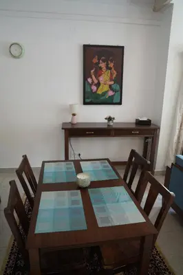 a dining room table with chairs and a painting on the wall at Perfect getaway in Mysore
