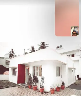 a white house with potted plants in front of it at Perfect getaway in Mysore