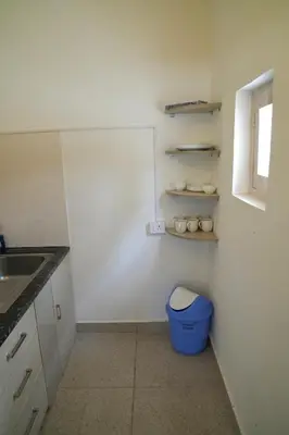 a bathroom with a blue trash can in a kitchen at Perfect getaway in Mysore
