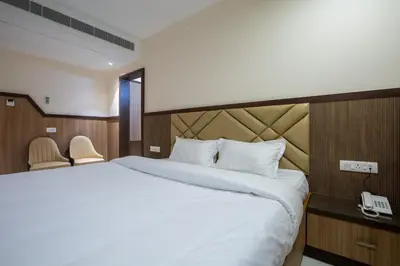 a bedroom with a large bed and a telephone at Hotel PRM Aruna Archadia in Erode