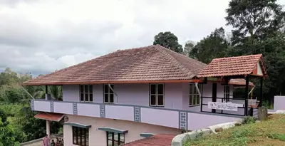 a house with a tiled roof on a hill at Keerthis Home Stay in Madikeri