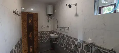 a bathroom with a sink and a toilet on the wall at Glasshouse Retreat by The Jungle stay groups in Vālpārai