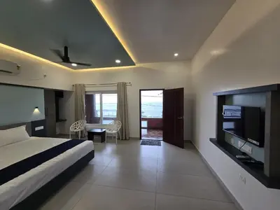 a bedroom with a bed and a television in a room at Sea Breeze Cherai Homestay in Pallipuram