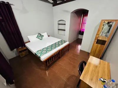 a bedroom with a bed and a wooden table at ERA Heritage Inn in Kozhikode